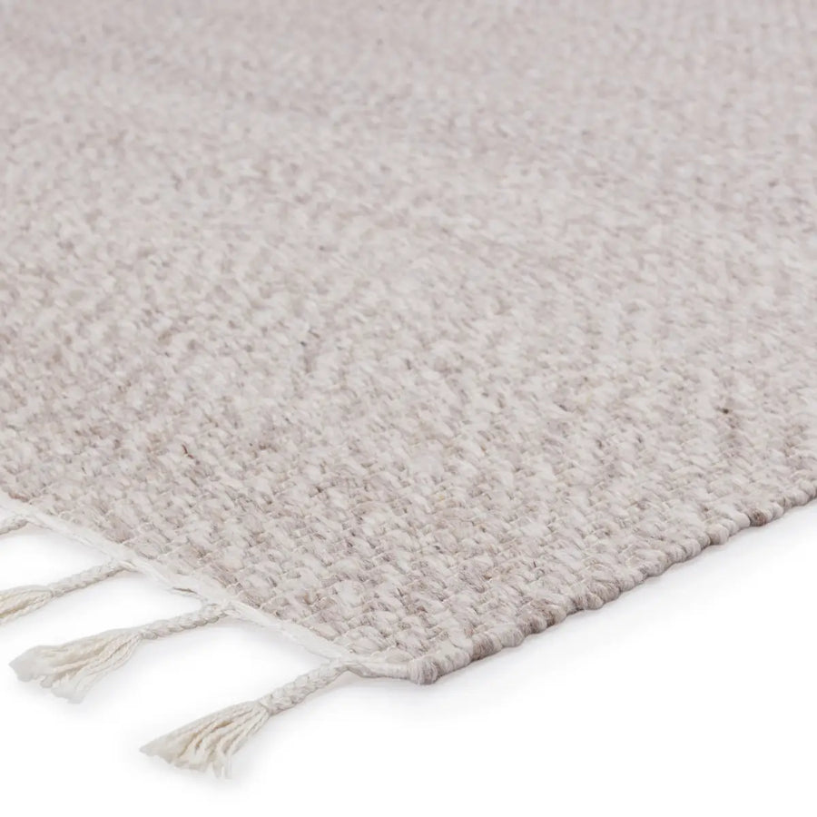 The flatwoven Majorca Adria Area Rug by Jaipur Living provides a warm and grounding accent to patios, kitchens, and dining rooms with durable PET yarn. The neutral cream and light gray colorway lends a refreshing, airy vibe, and the braided fringe adds a global touch.