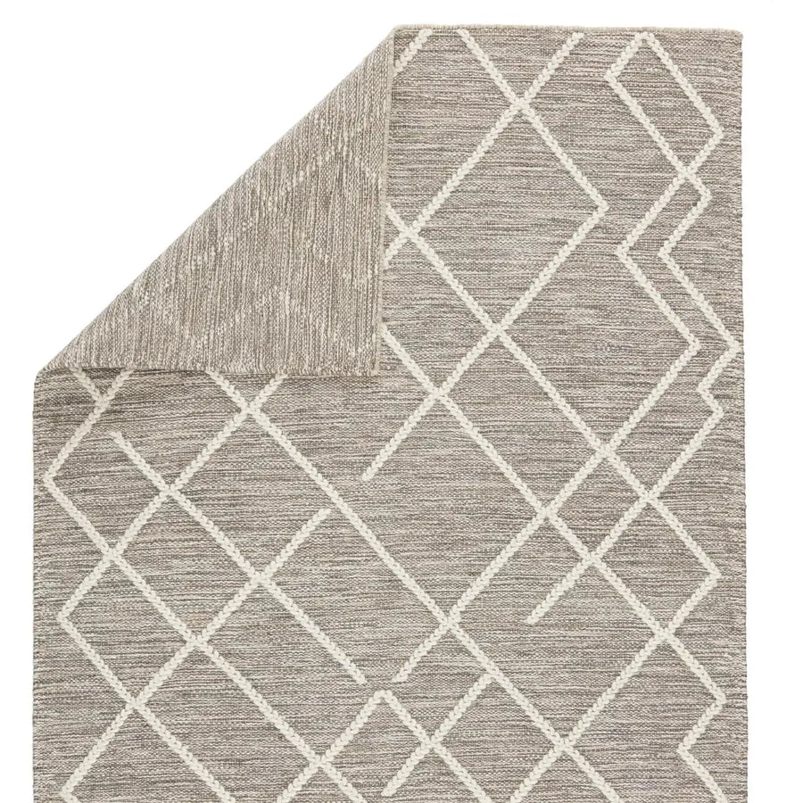 This Plateau Moab Fallen Rock / Whisper White Area Rug by Jaipur Living is crafted of jute, wool, and cotton. This showcases an ingenious braid weave technique that breathes life into the simple natural fiber foundation. The broken trellis motif lends geometric interest to the neutral gray and ivory colorway. PLT02