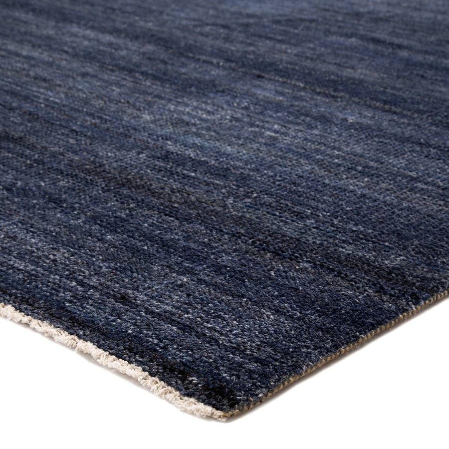 The Saga Origin Area Rug - Dark Denim by Jaipur Living, or SAG01, anchors a space with a solid, subtly striated design in a rich blue colorway. Hand knotted by skilled artisans, this durable wool accent marries simplicity and luxury with an exceptional quality.