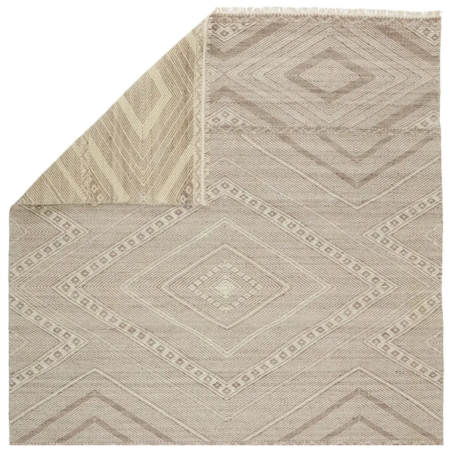 The handwoven Satori Suriya Area Rug by Jaipur Living features a versatile, neutral palette and an intricate tribal and diamond pattern. The short fringe detail adds texture to this light brown and cream-colored piece. This Moroccan style area rug fits perfectly in high traffic areas. 
