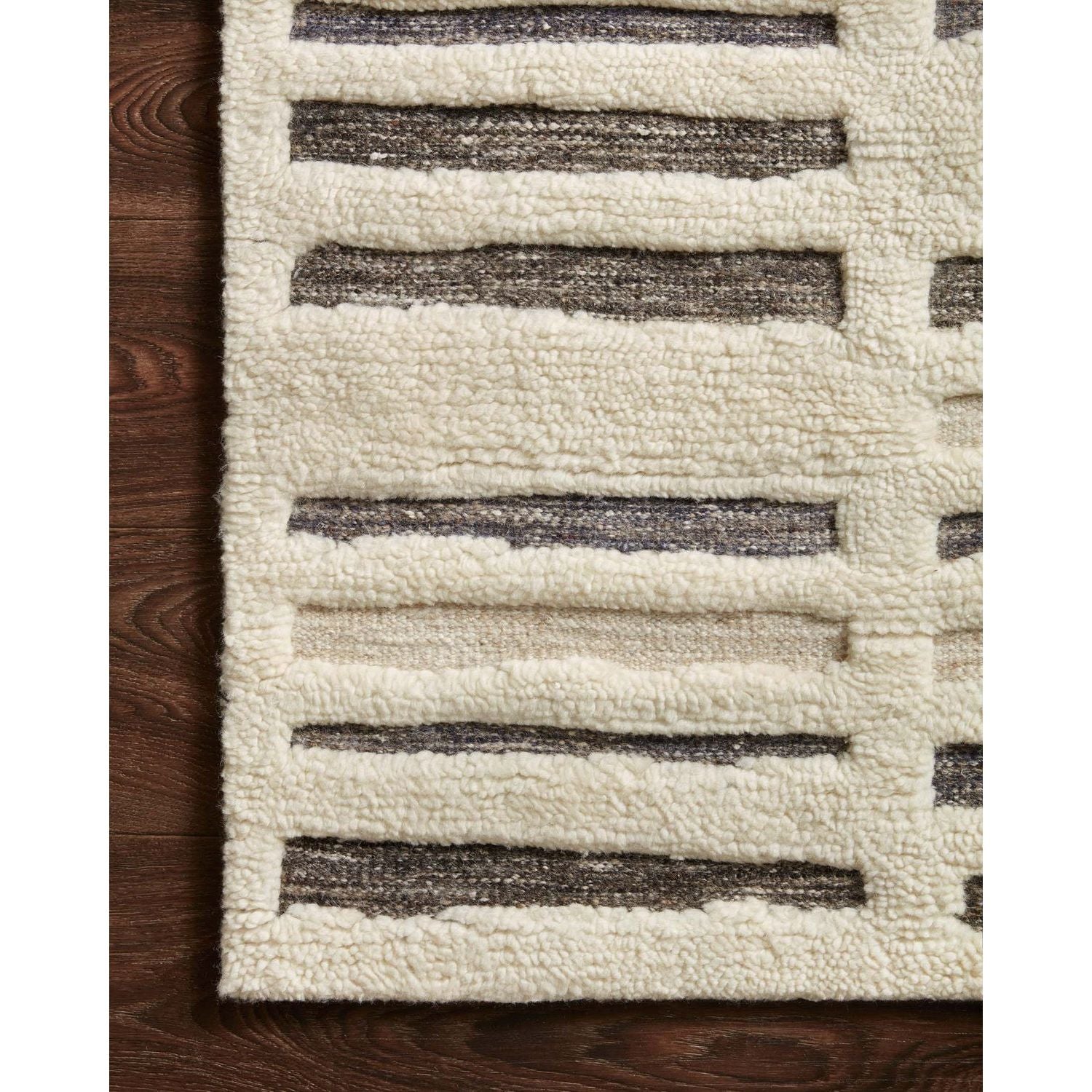 Dimensional yet soft, the Bennett Ivory / Charcoal Area Rug is hand-knotted of wool, viscose and polyester in India. Featuring a new carve like high-low pile, Bennett has an ivory base with abstract tonal designs. Plus, it's plush underfoot -- a great choice for your office, bedroom, or other medium traffic areas.   Hand Knotted 45% Wool | 32% Viscose | 17% Polyester | 6% Other Fibers Pile BEN-01 Ivory/Charcoal