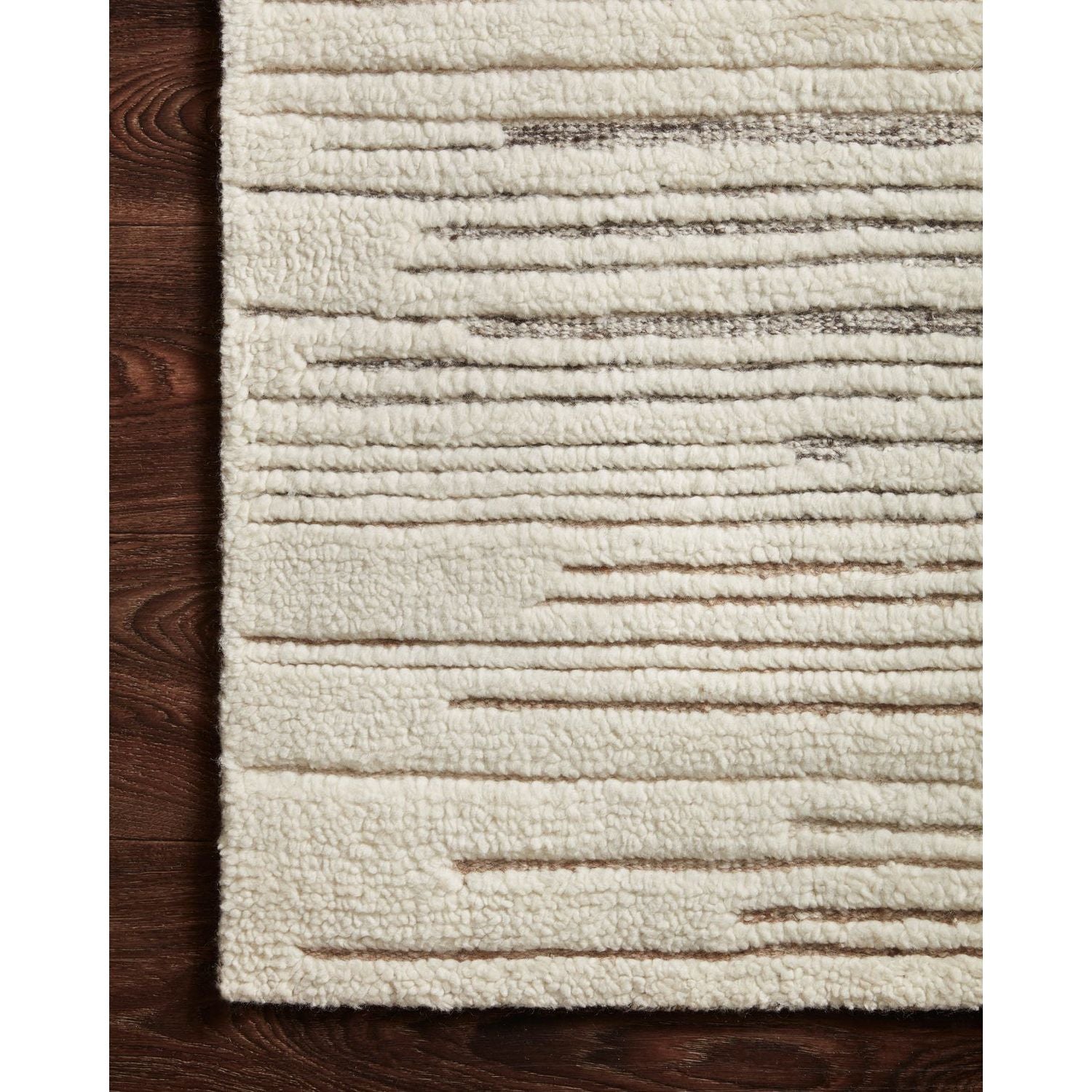Dimensional yet soft, the Bennett Ivory / Pebble Area Rug is hand-knotted of wool, viscose and polyester in India. Featuring a new carve like high-low pile, Bennett has an ivory base with abstract tonal designs. Plus, it's plush underfoot-- a great choice for your office, bedroom, or other medium traffic areas.   Hand Knotted 45% Wool | 32% Viscose | 17% Polyester | 6% Other Fibers Pile BEN-04 Ivory/Pebble