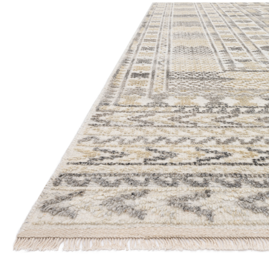 The Idris Ivory/Taupe area rug from Loloi is meticulously hand-knotted of viscose and wool. You will love this rug because the rug is:  Perfect for entryways, living rooms, and bedrooms Easy to clean and maintain Gorgeous with the intricate pattern and patina Warms up any room with the high / low pile Hand-Knotted 70% Viscose | 30% Wool ID-04 Ivory/Taupe