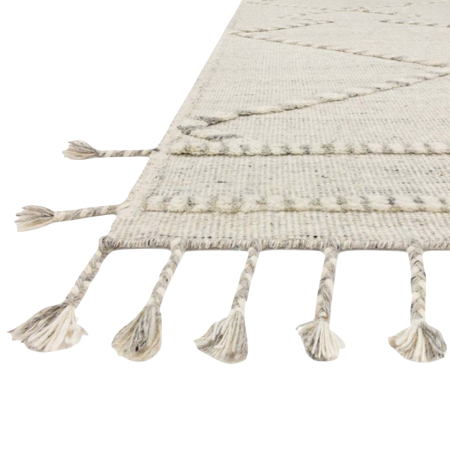 A new take on Moroccan style rugs, theIman Ivory/Light Grey Area Rug is hand knotted of wool and cotton by skilled artisans in India. The surface features linear and braided details, creating tonal variations that make each piece unique. Plus, each design is finished with playful fringe.  Hand Woven 81% Wool | 10% Cotton | 9% Polyester IMA-03 Ivory / Lt. Grey