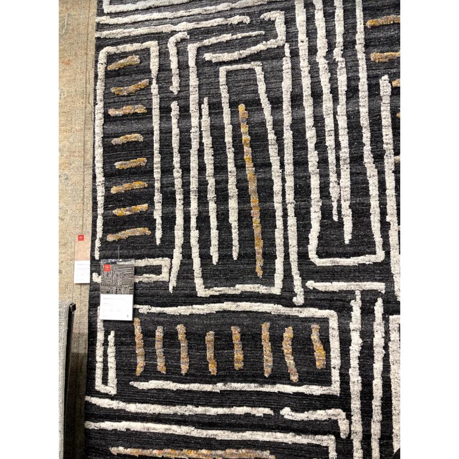 The Naomi Charcoal / Natural Area Rug is hand-knotted of wool and cotton by artisans in India. Naomi offers bold designs with earthy hues and features a high-low pile that adds depth and dimension, making each piece create the illusion of movement. A perfect rug for your living room, entryway, or other  Hand Knotted 89% Wool | 11% Cotton NAO-05 Charcoal/Natural