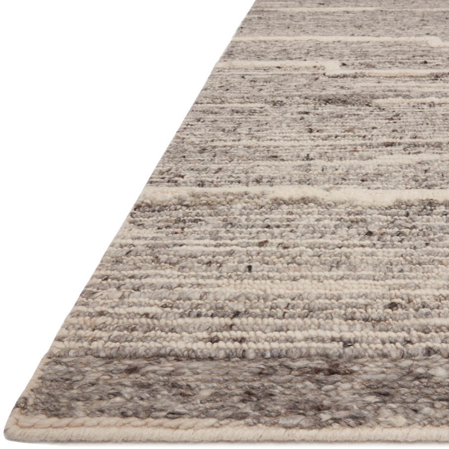 Hand-woven of 100% wool in India, the Loloi Rayan Charcoal / Ivory Area Rug, or RAY-03, sets the tone for a calming atmosphere. Each design is crafted of textural highs and lows paired with neutral tones to create and engaging understatement. The perfect rug for your bedroom, office, or other medium traffic area. 