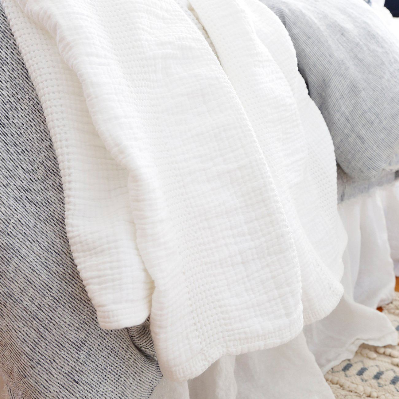 Crafted in Portugal, the Nantucket White Matelasse by Pom Pom at Home is a modern take on the matelasse with its beautiful interwoven weave. We love the soft, puckered appearance this brings to a bedroom.  Details & Care: 100% cotton. Machine wash cold; tumble dry low; warm iron as needed. Do not bleach