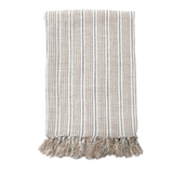 The Newport Throw by Pom Pom at Home is a soft, heavy knit linen that is hand-loomed and features a thicker natural stripe alongside a thin midnight stripe with tassels all along the edge.   Size: 50"x70" 100% linen Machine wash cold; tumble dry low; warm iron as needed   