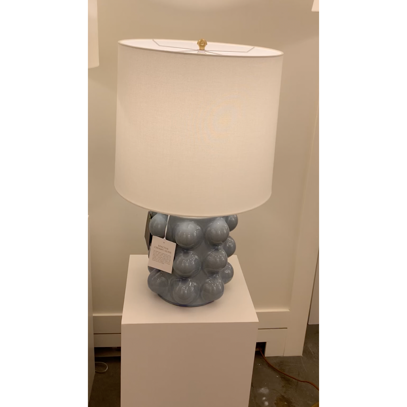 We love the form shape of this Vedra Medium Table Lamp. The dimmer feature makes it a perfect choice for your bedroom, living room, or other area that is perfect for setting the mood.   Reactive Ceramic Glazes Will Vary in Color and Texture  Designer: AERIN